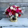 Bouquet of red, pink, and white roses in a gold vase