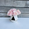 Pink roses in a small geometric white vase