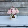 Pink roses arranged in a white geometric vase