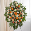 Standing floral spray with orange lilies, peach roses, and white blooms