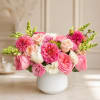 A soft and romantic floral arrangement designed in a modern white ceramic