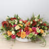 Colorful mixed flower arrangement in a white bowl vase