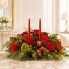 Red candle centerpiece with roses, carnations, pinecones, and ribbon