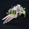 Gorgeous wrist corsage featuring miniature calla lilies, spray roses, ranculus, scabiosa, and