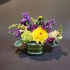 Yellow dahlia bouquet with purple and white flowers in a striped glass vase