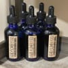 Five blue dropper bottles labeled liquid flower food