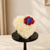 Heart-shaped white floral arrangement with red and blue roses on a black stand