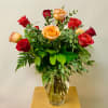 Bouquet of red and peach roses in a clear glass vase