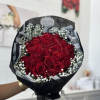 Bouquet of red roses with white baby's breath in black wrapping