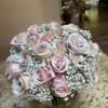 Bouquet of pale pink roses and baby's breath in a glass vase
