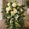 Cream rose bouquet with cascading greenery on a wooden table