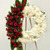 Two floral wreaths on easels, one red and one white.