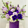Purple and white floral arrangement in a purple vase