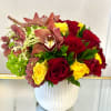 Bouquet of red and yellow roses with orchids in a white vase