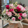 Bouquet of pink and red roses wrapped in cream paper