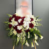 Standing floral spray with red roses, white orchids, and white calla lilies