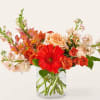 Orange and peach flowers in a clear glass vase