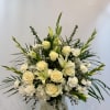 White roses and lilies arranged in a clear vase
