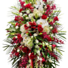 Large standing spray of red and white flowers with palm fronds