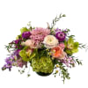 Mixed bouquet in a low black vase with pink, purple, and green blooms