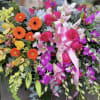 Colorful floral spray with roses, gerbera daisies, lilies, and orchids
