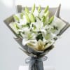 Bouquet of white lilies wrapped in gray paper with a ribbon