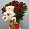 Red roses arranged with a teddy bear in a red gift box