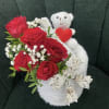 Red roses with baby's breath and a white teddy bear holding a heart