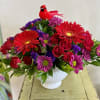 Red and purple mixed bouquet in a white vase with a red bird decoration