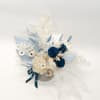 Blue and white floral arrangement in a round container with ribbon