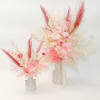 Two pink and white dried floral arrangements in small vases