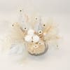 Cream-colored floral arrangement with white blooms and dried accents