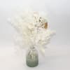 White dried floral arrangement in a frosted glass vase