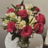Pink roses and white lilies arranged in a clear glass vase