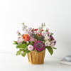 Mixed pink and purple flowers in a wooden basket