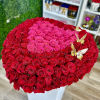 Large heart-shaped arrangement of red and hot pink roses on a white box with gold butterflies.