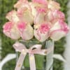 Compact arrangement of white roses edged in pink in a square glass vase with a pink ribbon bow