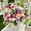 Pink, white, and lavender rose and carnation arrangement in a white box with ribbon and butterfly accent