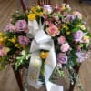 Large floral wreath with pastel roses and a white ribbon bow