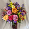 Mixed bouquet of roses and purple filler flowers in a burgundy vase