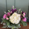 A heartfelt arrangement designed with soft pink blooms, creamy white, and lush