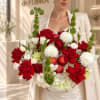 Woman holding a bouquet of red and white flowers with apples