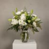 White roses and daisies in a glass vase with a satin ribbon