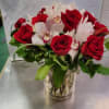 Red roses and white orchids arranged in a clear glass vase