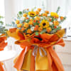 Bouquet of yellow and orange flowers wrapped in bright orange paper