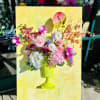 Colorful floral arrangement in a lime green vase on a yellow canvas