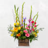 Tall mixed bouquet in a wooden box with lilies, tulips, and gerbera daisies