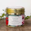 Gold tin candle with floral label on a wooden surface