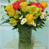 Bouquet of yellow and red flowers in a clear glass vase