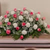 Pink and white floral casket spray with greenery